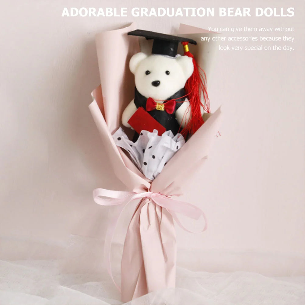 Graduation-themed teddy bear in a bouquet with pink wrapping on a light background
