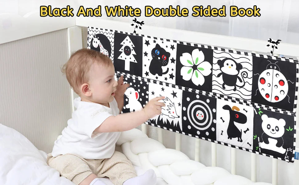 Baby interacting with a black and white double-sided book in a crib.