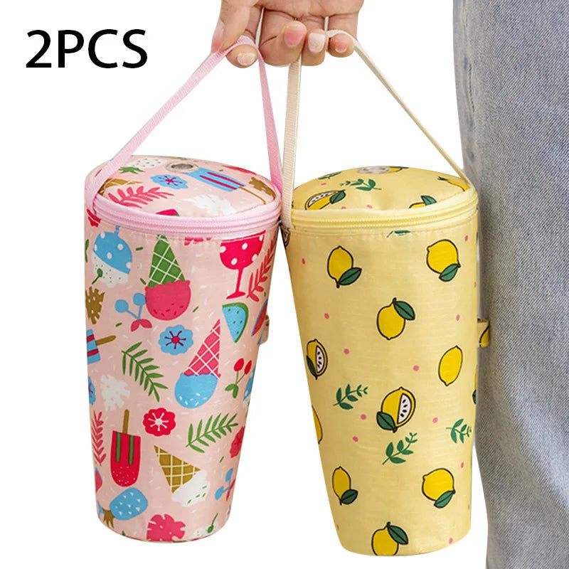 Two cylindrical insulated bags with colorful patterns held by a person.