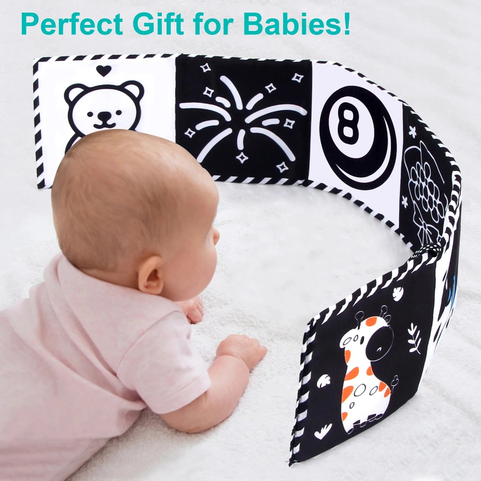 Baby lying on a black and white play mat with decorative patterns, labeled 'Perfect Gift for Babies'.