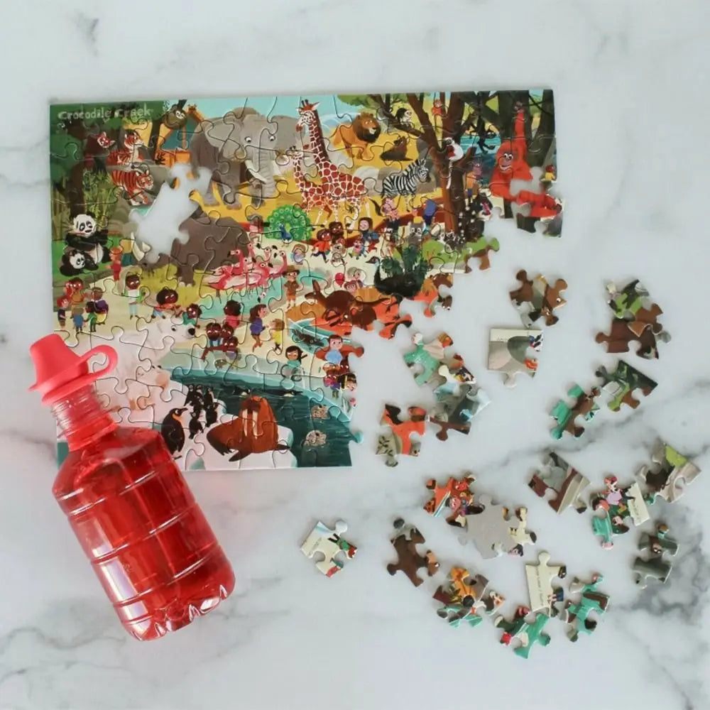 Jigsaw puzzle with animal-themed pieces on a marble surface, accompanied by a red water bottle.