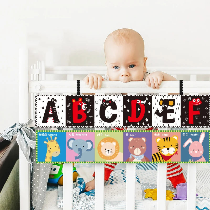 Baby in a crib with an alphabet and animal-themed rail cover.