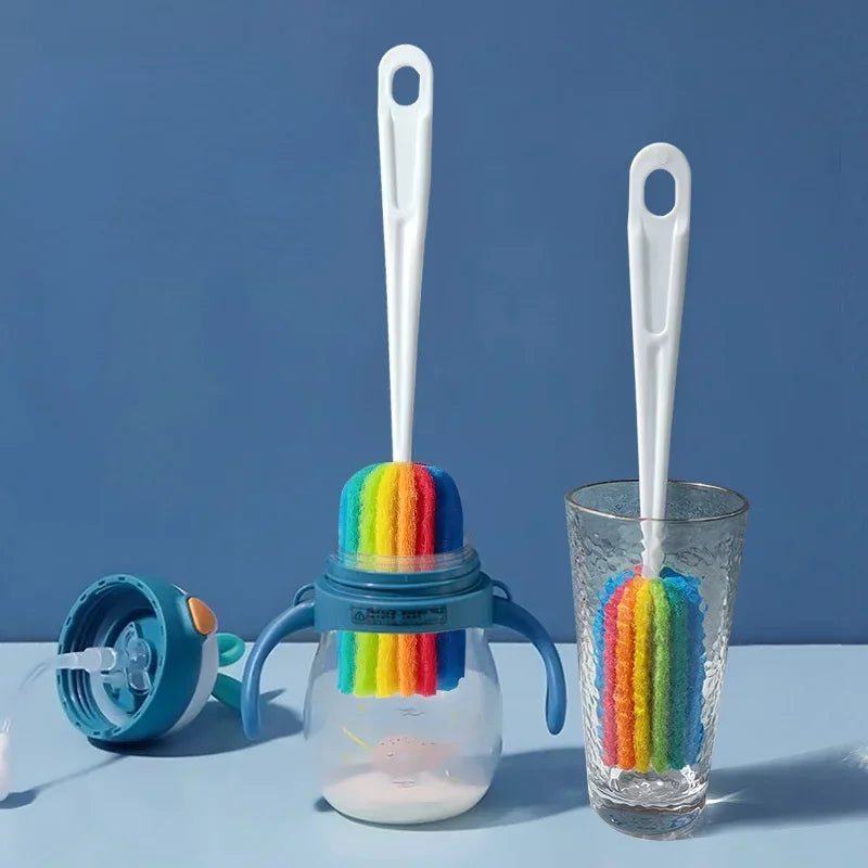 Two bottle brushes with rainbow bristle heads on a jar and glass against a blue background