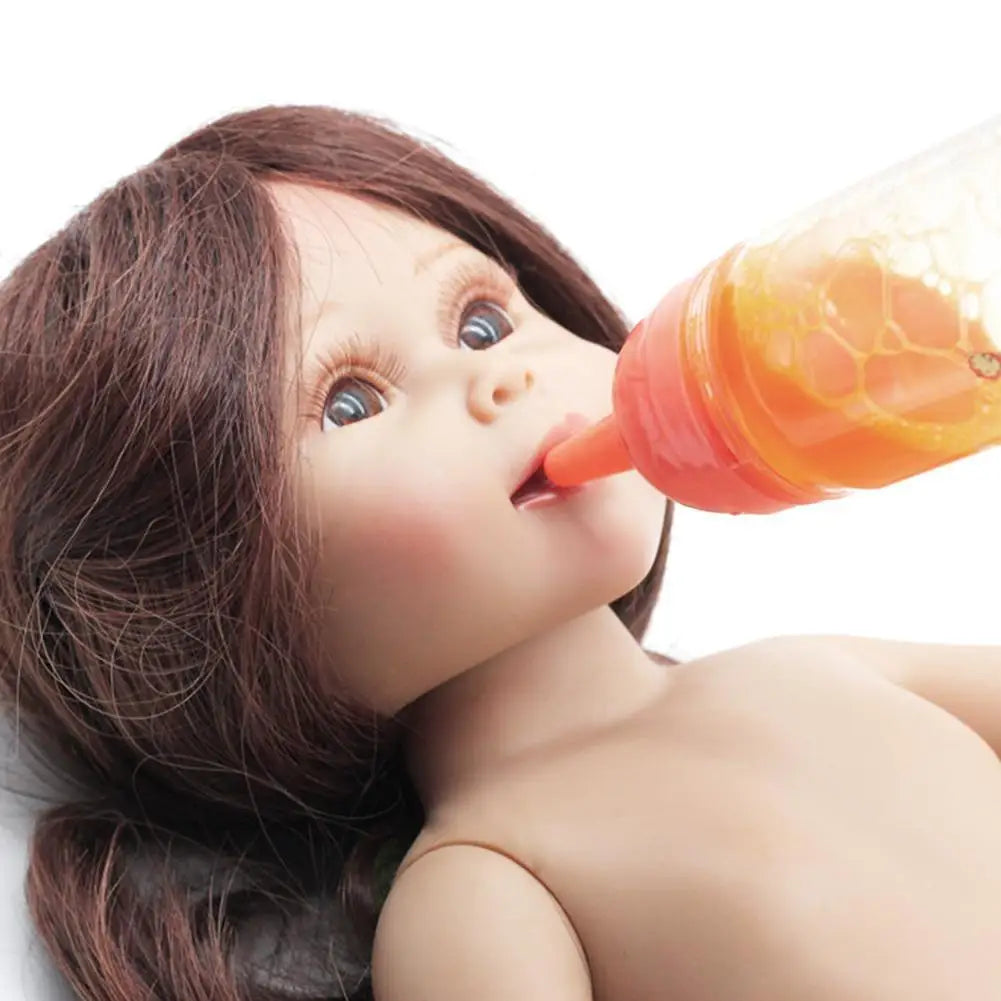 Close-up of a doll drinking from an orange bottle with a white background