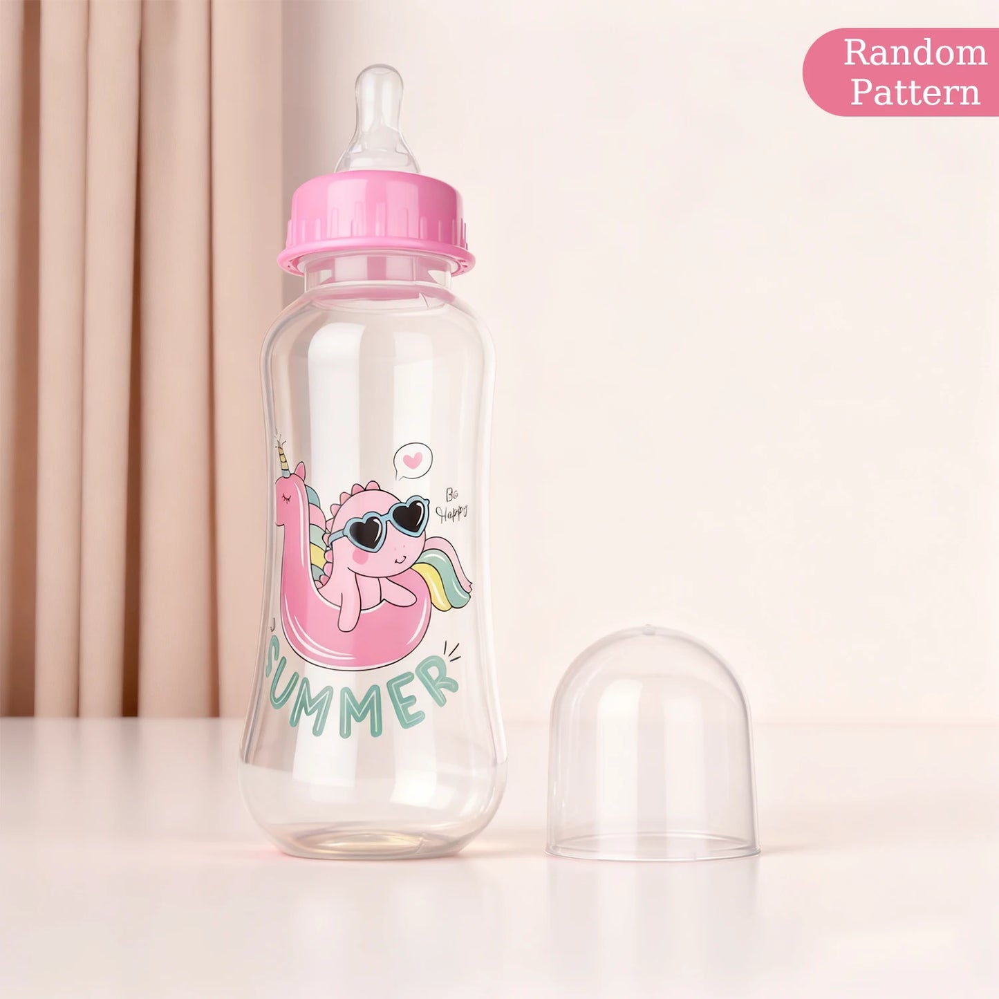 Baby bottle with pink cap and cartoon design on a light background