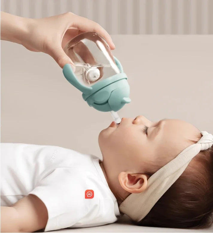 Baby lying on a couch with a hand holding a teal pacifier