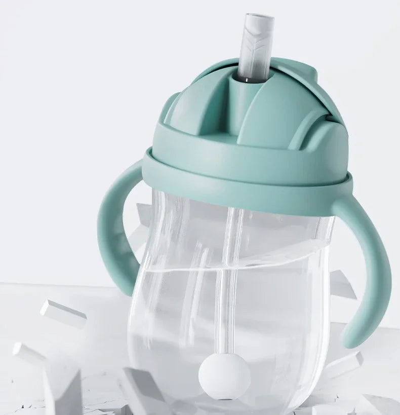Clear sippy cup with a light blue lid and handles on a white background