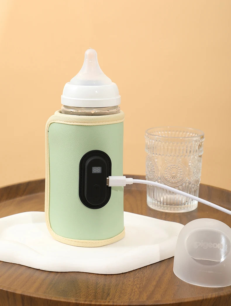 Green baby bottle warmer with a glass of water on a wooden surface