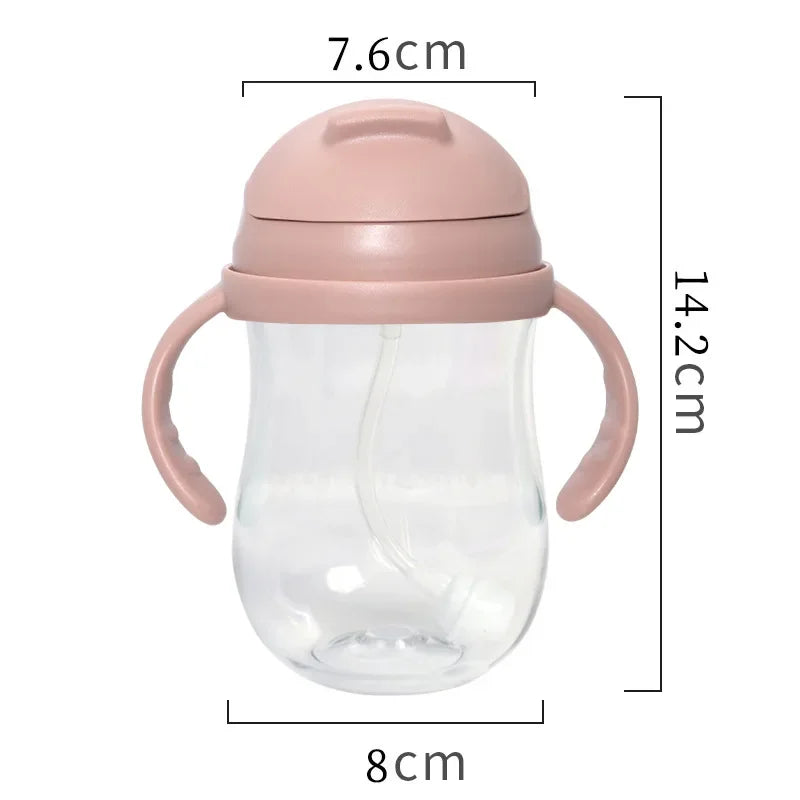 Clear baby bottle with pink lid and handles, showing dimensions on a white background
