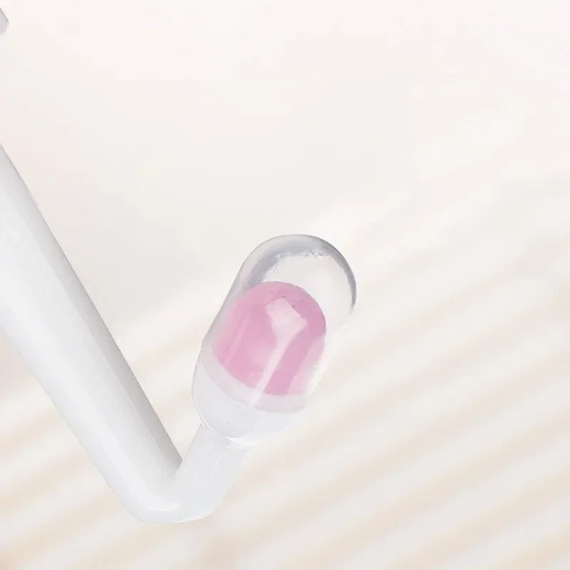 Close-up of a white earbud with a pink interior on a light background