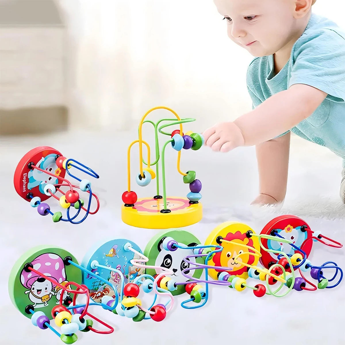 Colorful baby toys with a child interacting with them on a light surface.