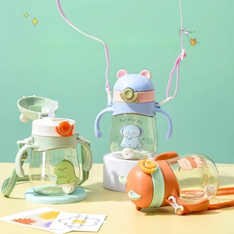 Set of colorful children's cups with animal designs on a light green background