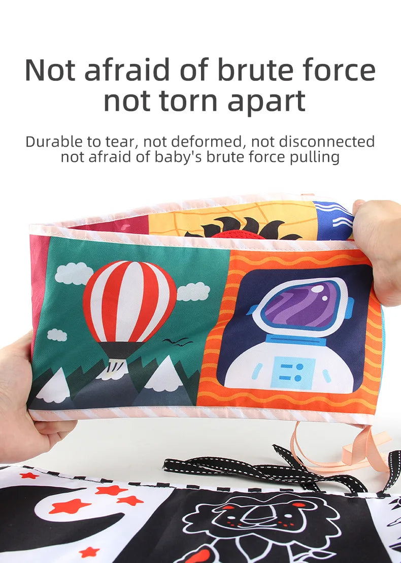 Colorful soft book held by a hand with cartoon designs on a white background