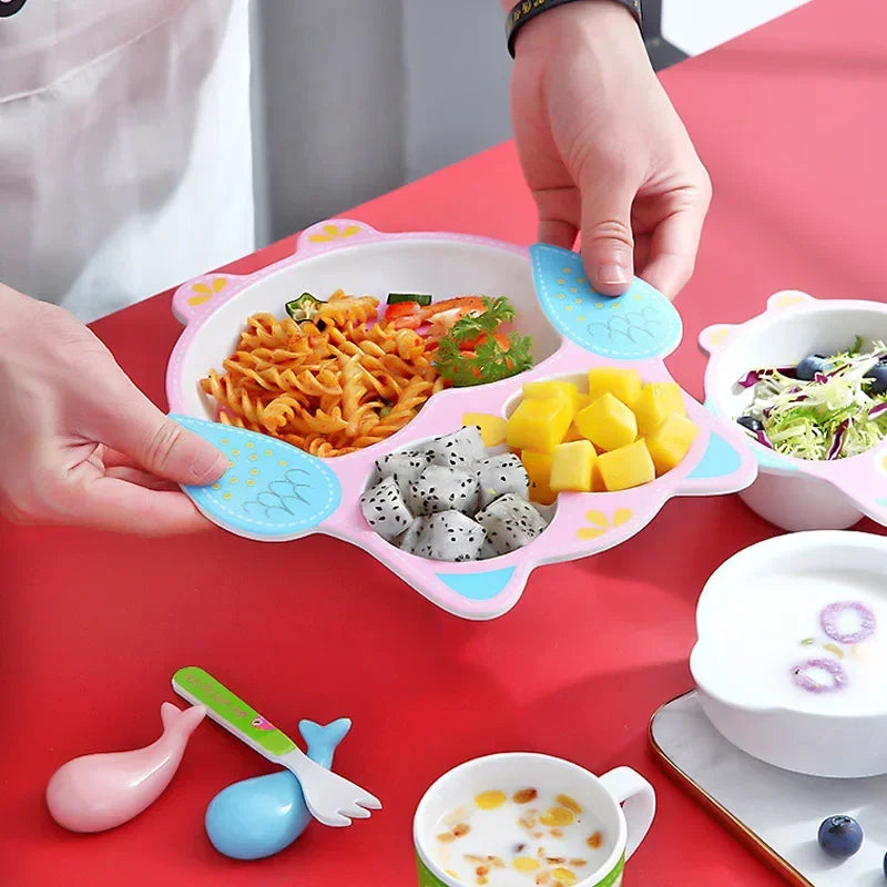 Children's plate with compartments filled with food on a red table.