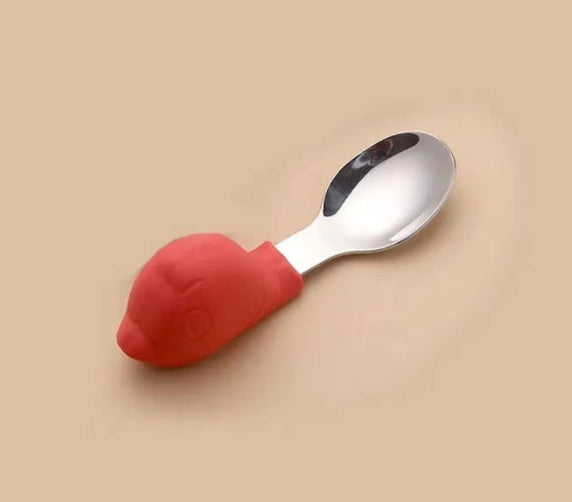 Spoon with red silicone handle on a beige background