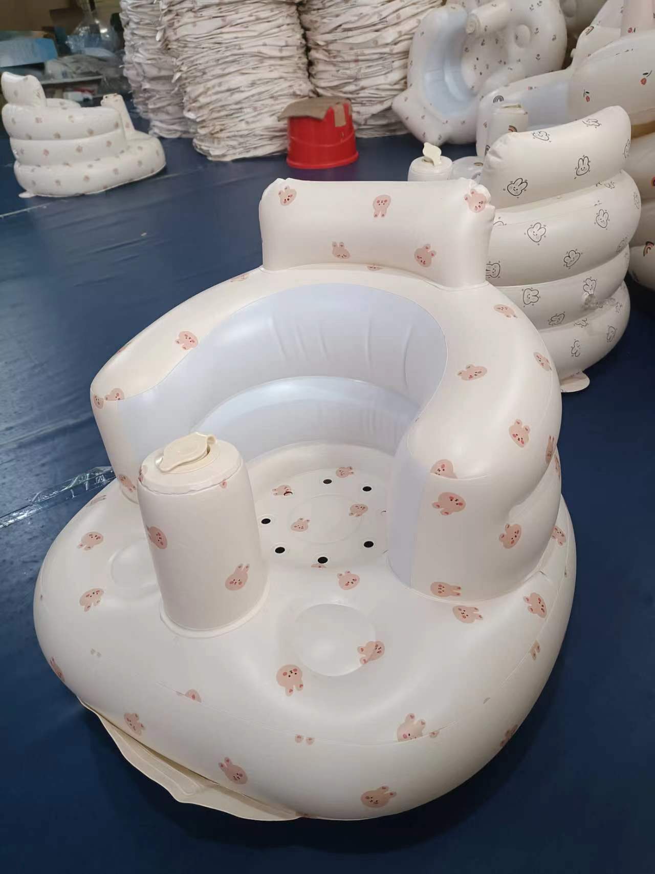 Inflatable baby seat with floral patterns on a blue surface