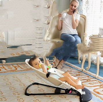 Woman sitting on a chair with a baby in a baby bouncer in a home setting.