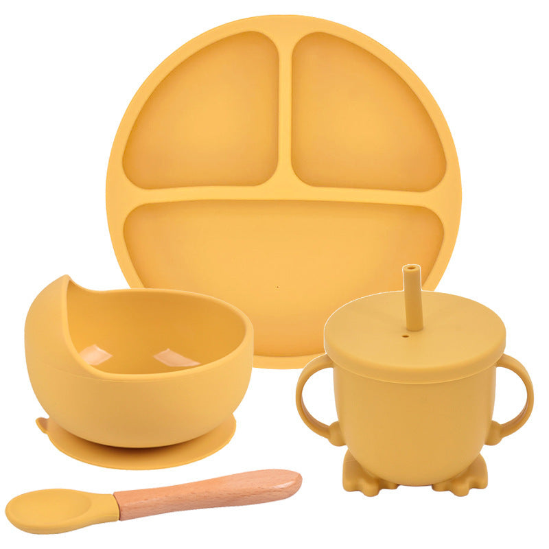Yellow silicone dining set with plate, bowl, cup, and spoon on a white background