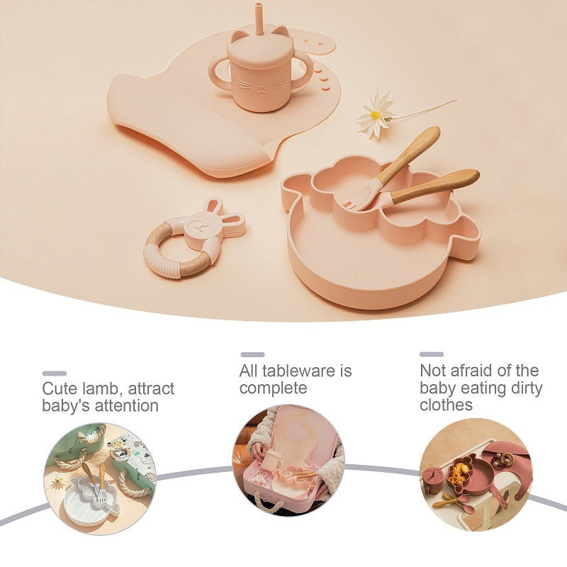 Set of pink children's tableware including plates, cups, and cutlery on a beige background.