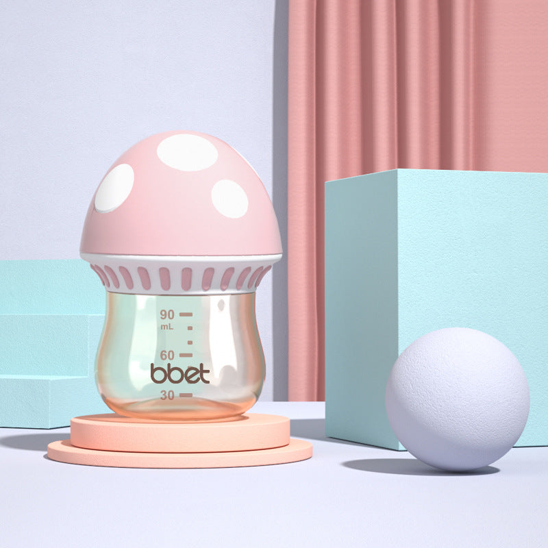 Baby bottle with pink cap and base on a light blue background