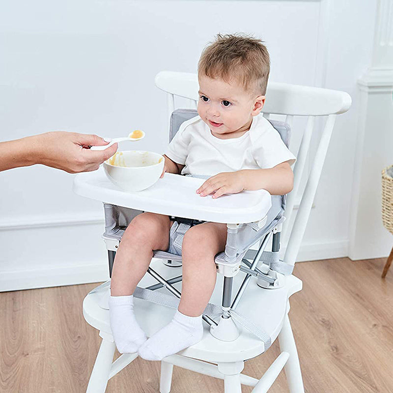 Child in a high chair being fed by an adult in a home setting