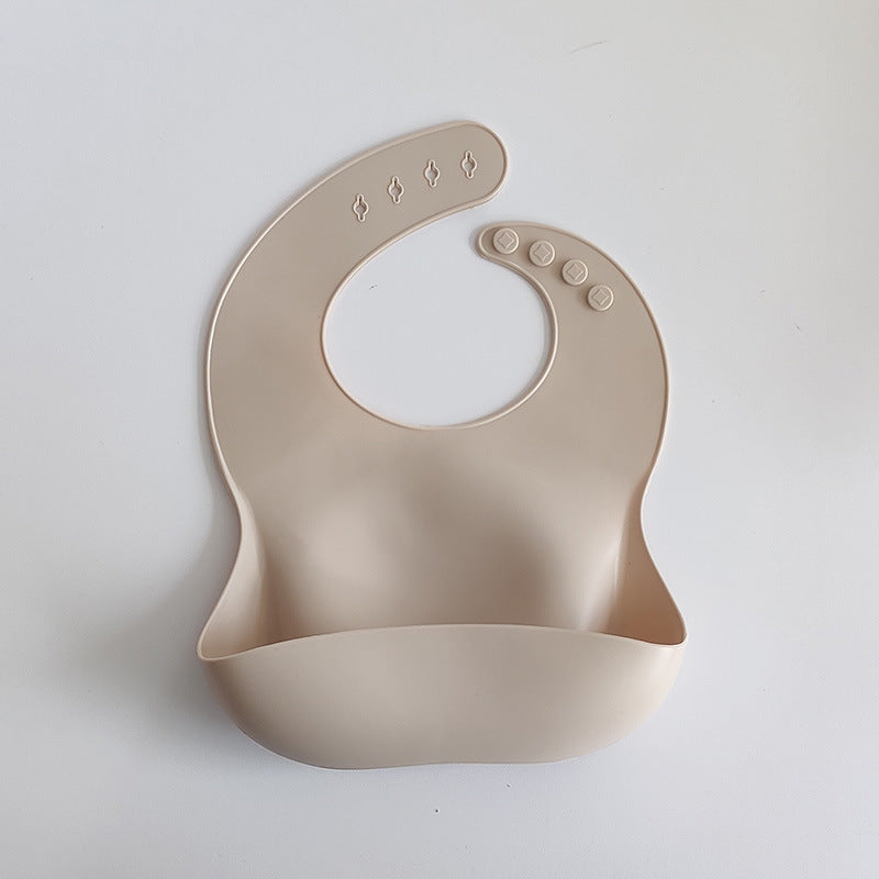 Beige silicone bib on a light gray background