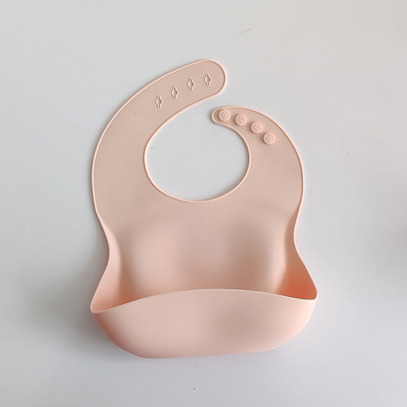 Pink silicone bib on a light gray background