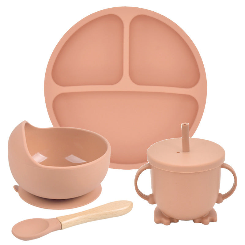 Set of silicone dining utensils including a plate, bowl, cup with straw, and spoon on a white background.