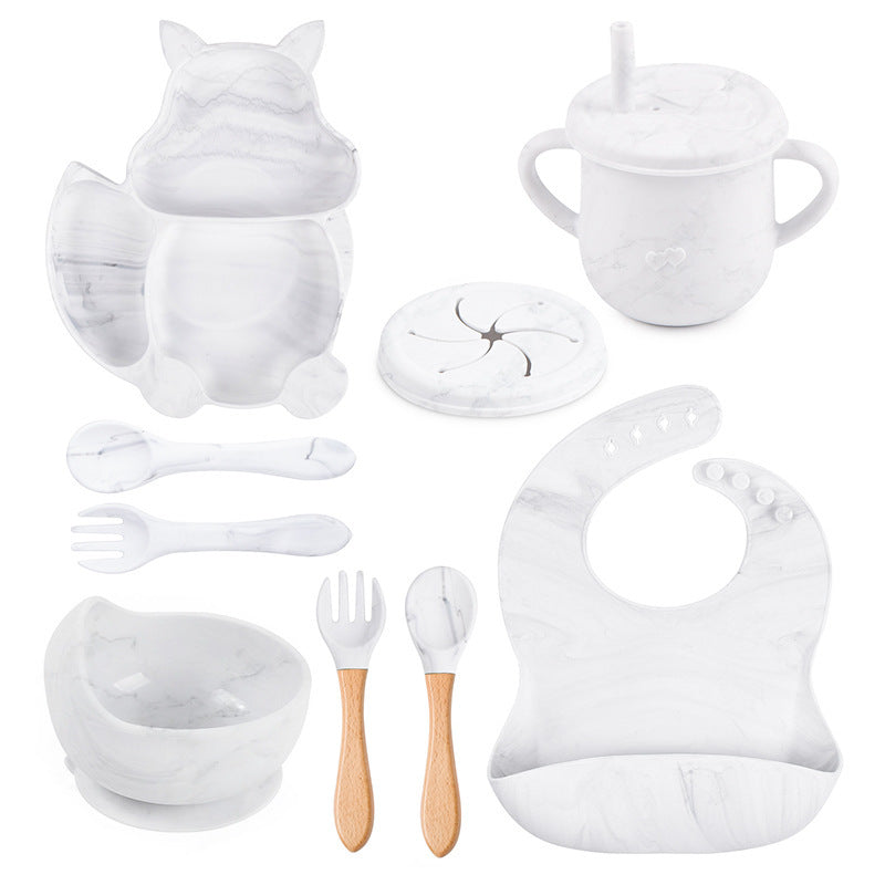 Collection of white baby feeding and dining utensils on a white background