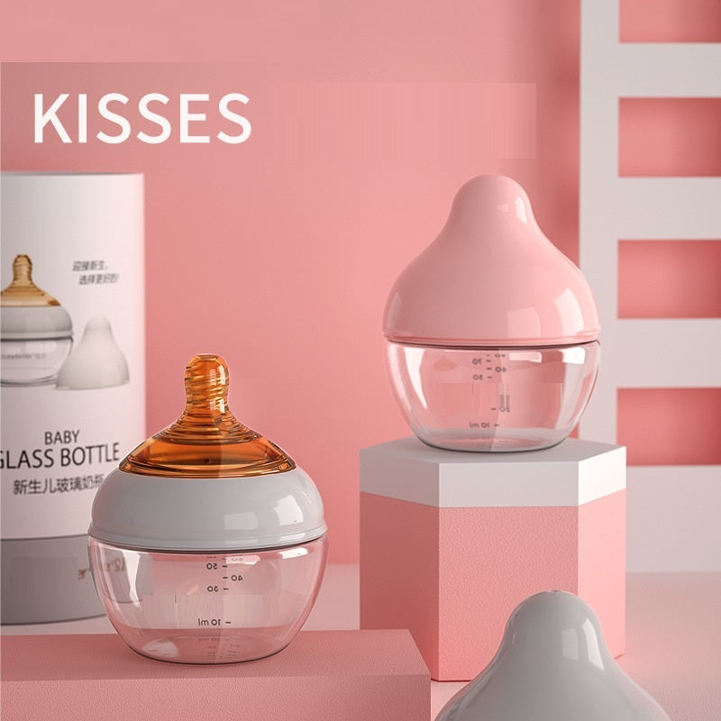 Baby glass bottles with pink and orange accents on a pink background, featuring the word 'KISSES'.